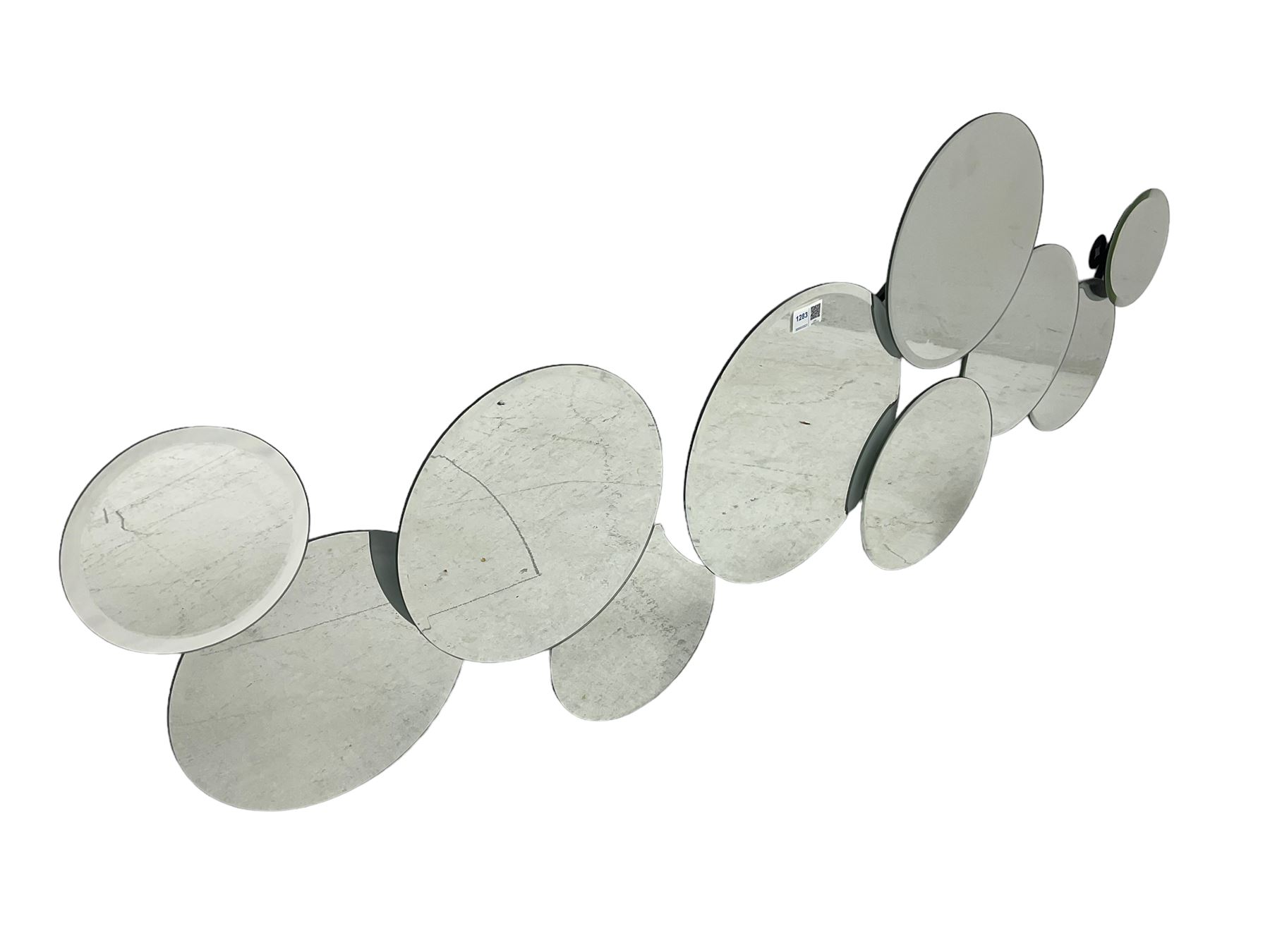 Contemporary abstract circular mirror, comprised of interconnecting bevelled plates of varying sizes