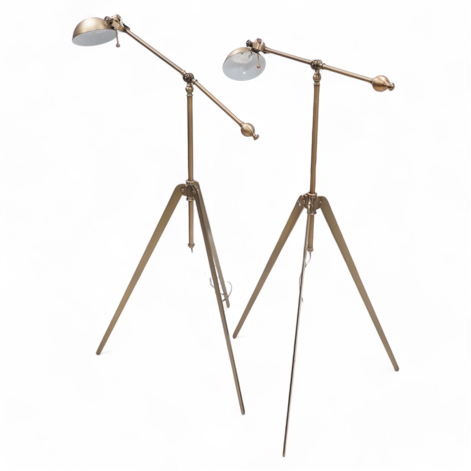 Two burnished metal adjustable tripod standard lamps