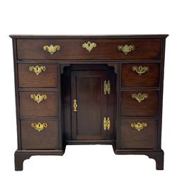 George III mahogany kneehole desk, moulded rectangular top over one long drawer, six short drawers and recessed panelled cupboard, cock-bead moulded frame, fitted with shaped brass handle plates with engraved decoration, on bracket feet 