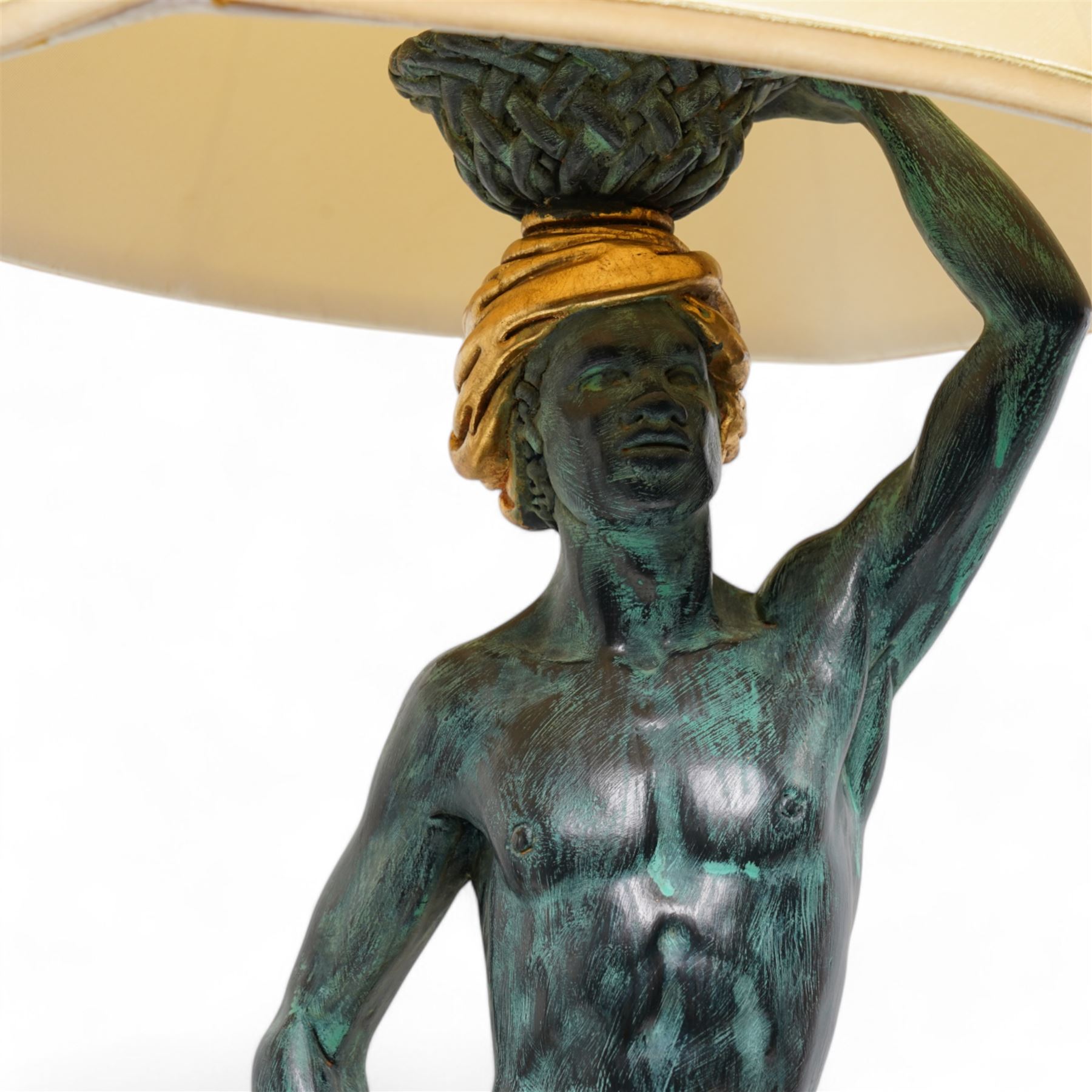 Pair of Italian figural carved table lamps, each modelled as a semi-nude male figure holding a basket above their heads, with green patinated and gilt decoration, on hexagonal bases, H68cm excluding fitting