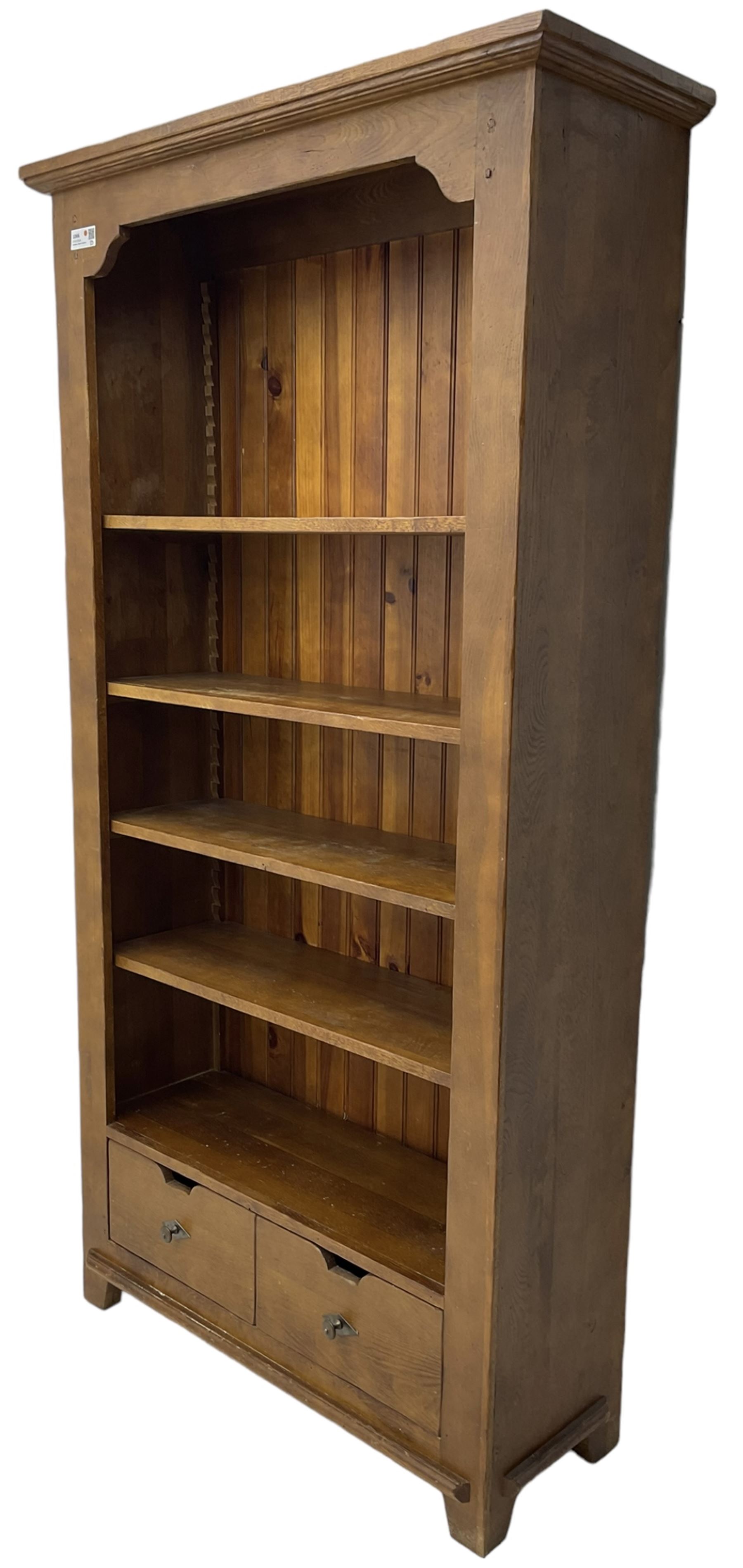 John Lewis - 'Bergerac' oak bookcase, projecting moulded cornice over four adjustable open shelves, two drawers to the base with cut-out handles, on square tapered supports