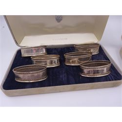 Two sets of six modern silver napkin rings, each of oval form, with Greek key decoration, hallmarked Ari D Norman, London 1986, both in fitted cases