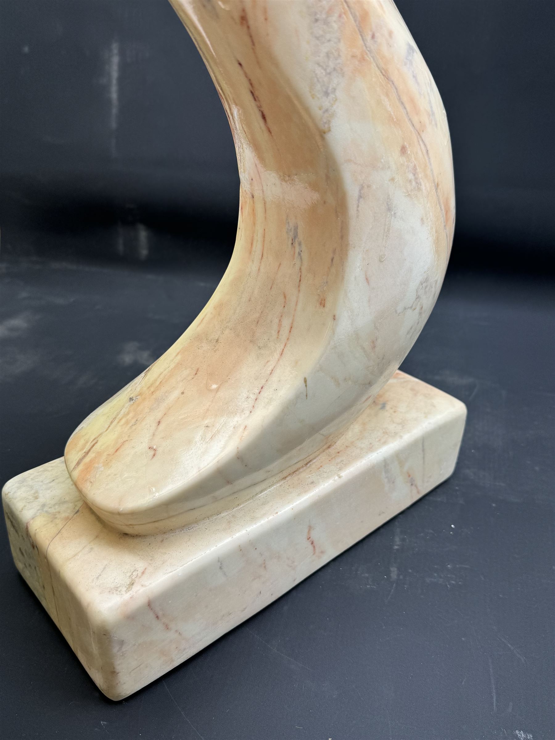 Abstract marble sculpture modelled as a mother and child on a rectangular base, H62cm