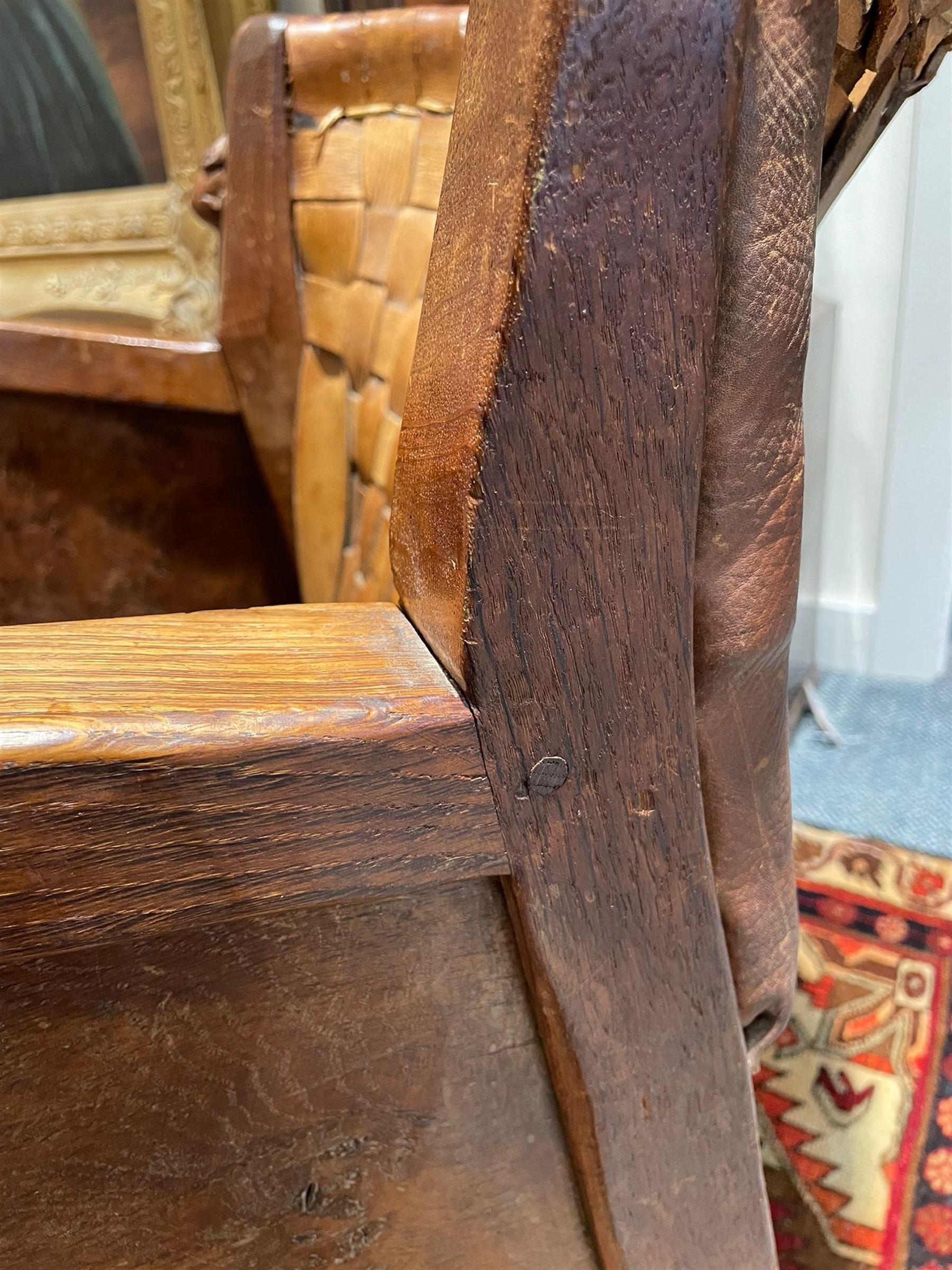 Mouseman - unusual circa. 1930s adzed oak tub-shaped armchair, barrel-back with woven leather, the upright carved with mouse signature, figured panelled sides enclosing panelled seat, arched seat rail, stile supports with block feet on castors, by the workshop of Robert Thompson, Kilburn  

Notes: made by apprentice Graham Hayes (1914-1943). Hayes went on to become a founding member of the Small Scale Raiding Force (SSRF), a special commando unit under the Special Operations Executive (SOE), established by Winston Churchill in 1940. Tragically, he was captured in 1942 and held prisoner by the Gestapo until his execution in 1943. Recently, Hayes has been featured in Guy Ritchie's film 'The Ministry of Ungentlemanly Warfare' under the name 