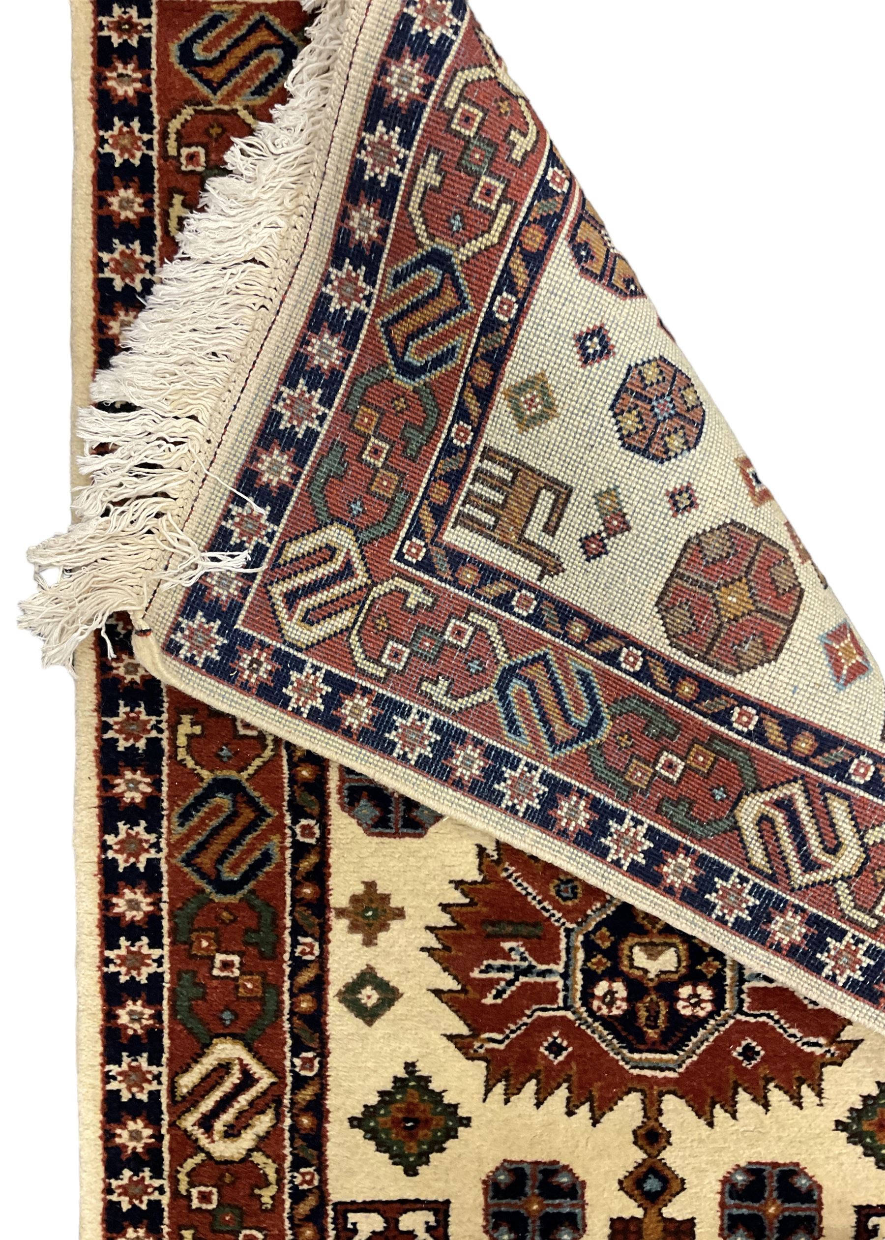 Persian design ivory ground rug, six lozenge medallions within a field of stylised animal and geometric motifs, the guarded border decorated with interconnected S motifs 