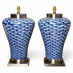 Pair of large lamps of tapering form, decorated in blue myriad fish pattern, on brushed ch...