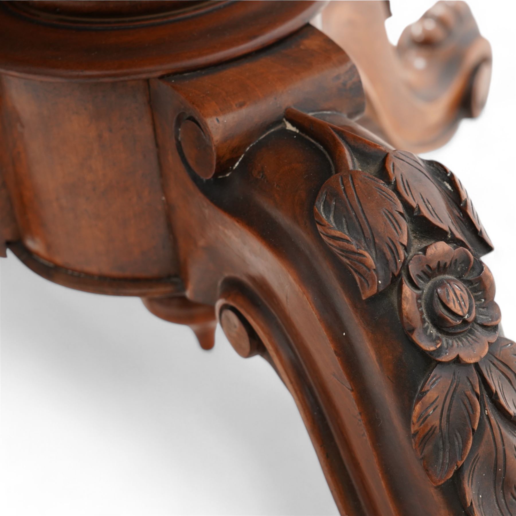 Victorian figured walnut breakfast or centre table, circular tilt-top with carved edge and quarter-matched veneers, turned pedestal with foliate carved baluster on three out splayed supports decorated with floral carvings and scrolled terminals, on brass castors 