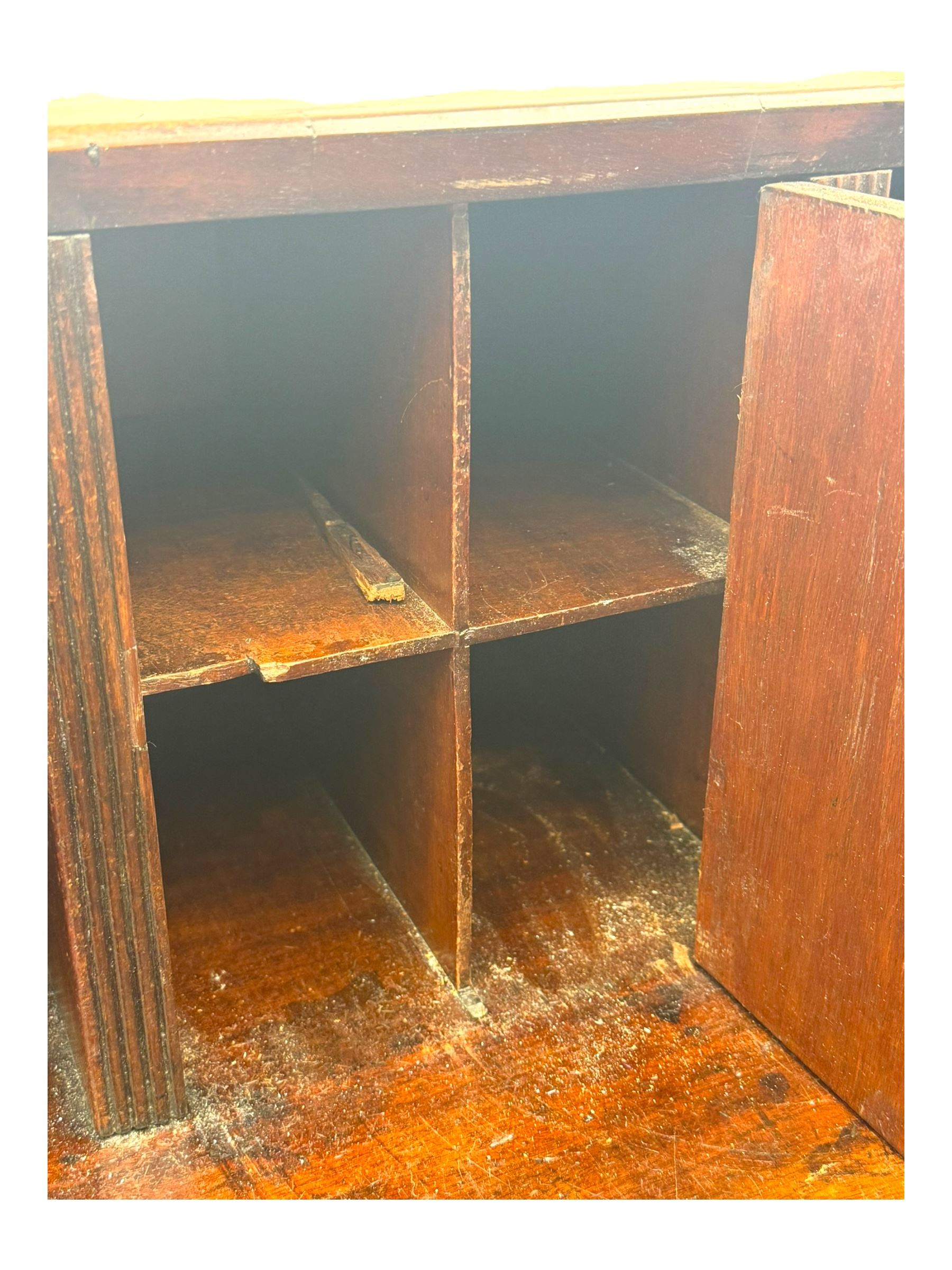 George III mahogany bureau, the fall-front enclosing fitted interior with pigeonholes and central cupboard, over an arrangement of nine short drawers surrounding a central cupboard, on shaped bracket feet