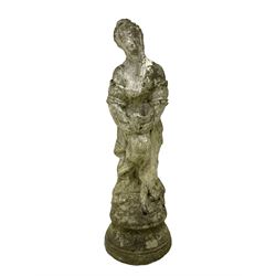 Weathered and painted cast stone garden statue, in the form of an Italian maiden with an ornate tied hairstyle and flowing gown, holding a wounded dove, on a turned base with garland decoration