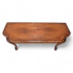 Pair of Georgian walnut console tables, the shaped rectangular cross-banded top with moulded edge over a banded frieze, raised on moulded cabriole supports decorated with scalloped shell and scroll carved knees, terminating to hairy hoof feet