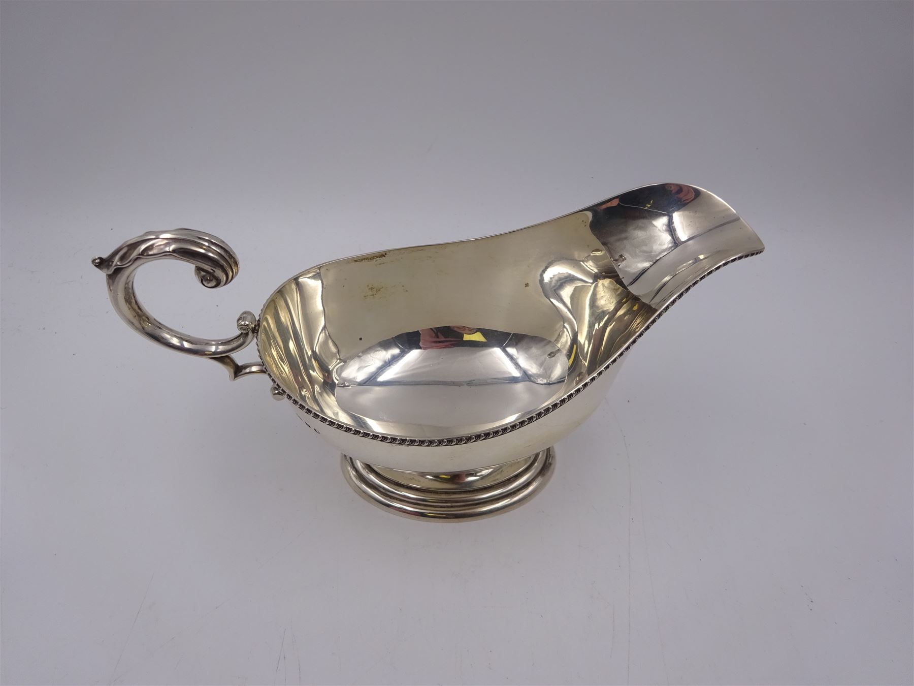 1930s silver sauce boat, of typical form, with oblique gadrooned rim and acanthus capped flying C scroll handle, by William Hutton & Sons Ltd, Sheffield 1934, H11cm