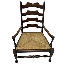 Georgian design oak country low armchair, waived ladder back over rush seat, raised on turned  supports united by stretchers; together with matching stool