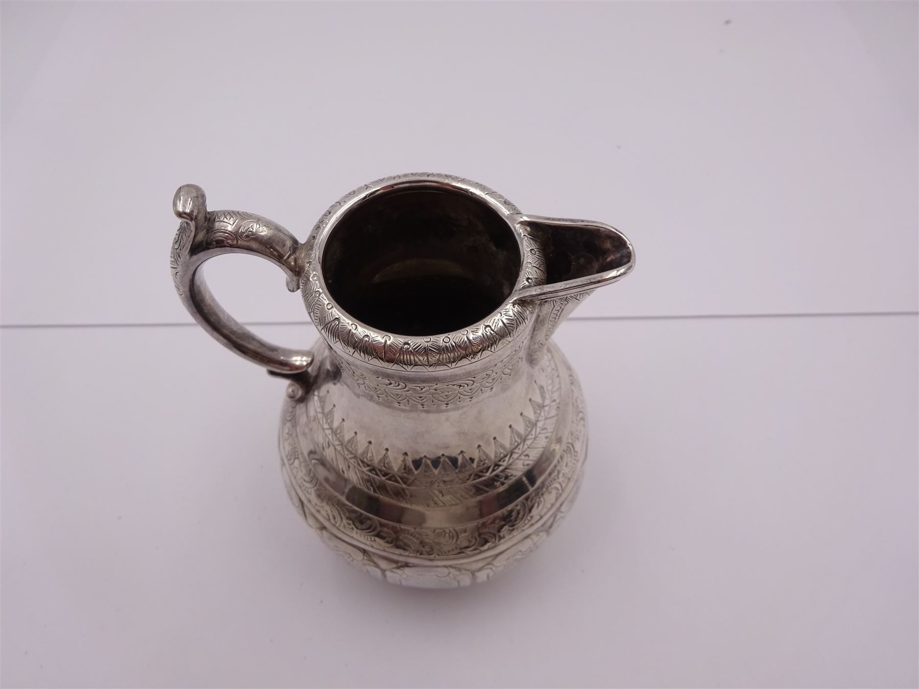 Arts and Crafts silver jug, of bellied form with C handle, the body engraved with a band of floral panels, with engraved scrolling and foliate decoration throughout, hallmarked hallmarked Samuel Smily, Goldsmiths Alliance, London 1873, H13cm