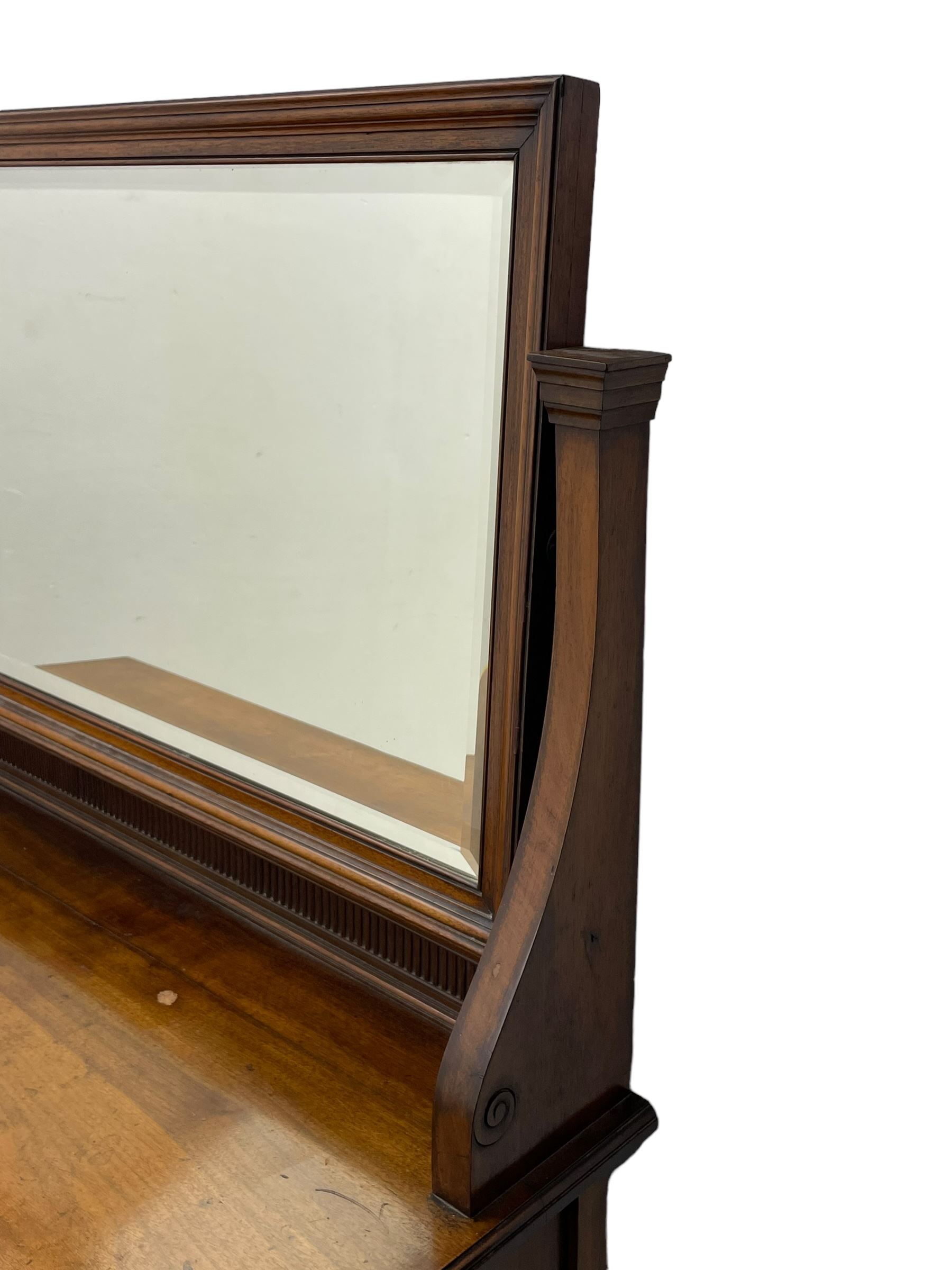 Late 19th century walnut dressing table, wide rectangular bevelled swing mirror in moulded frame, shaped horns carved with scrolls, moulded rectangular top over seven drawers, on square tapering supports with spade feet 