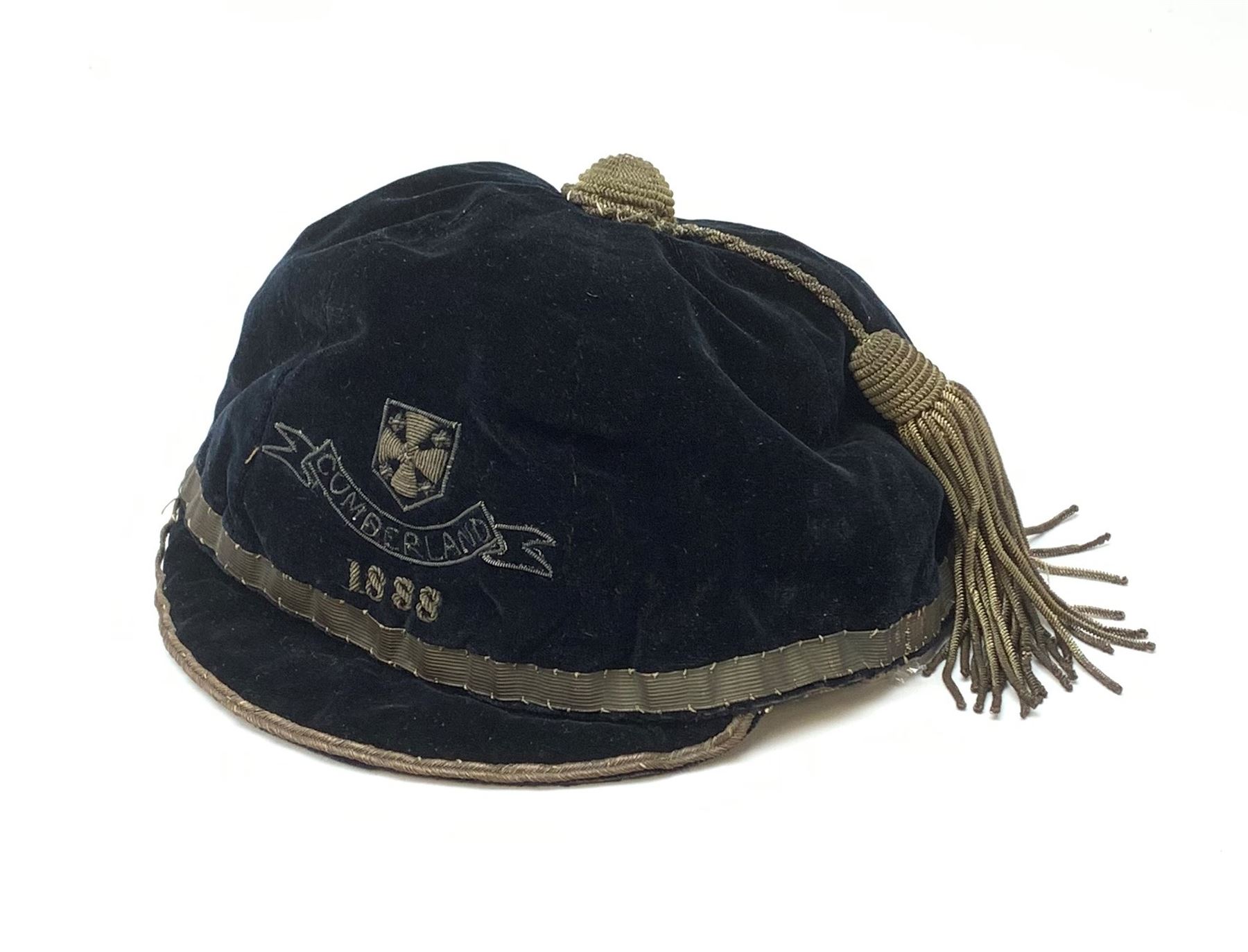 A Victorian rugby cap for Cumberland, the black velvet cap with gold coloured thread and tassel, dated 1888. 