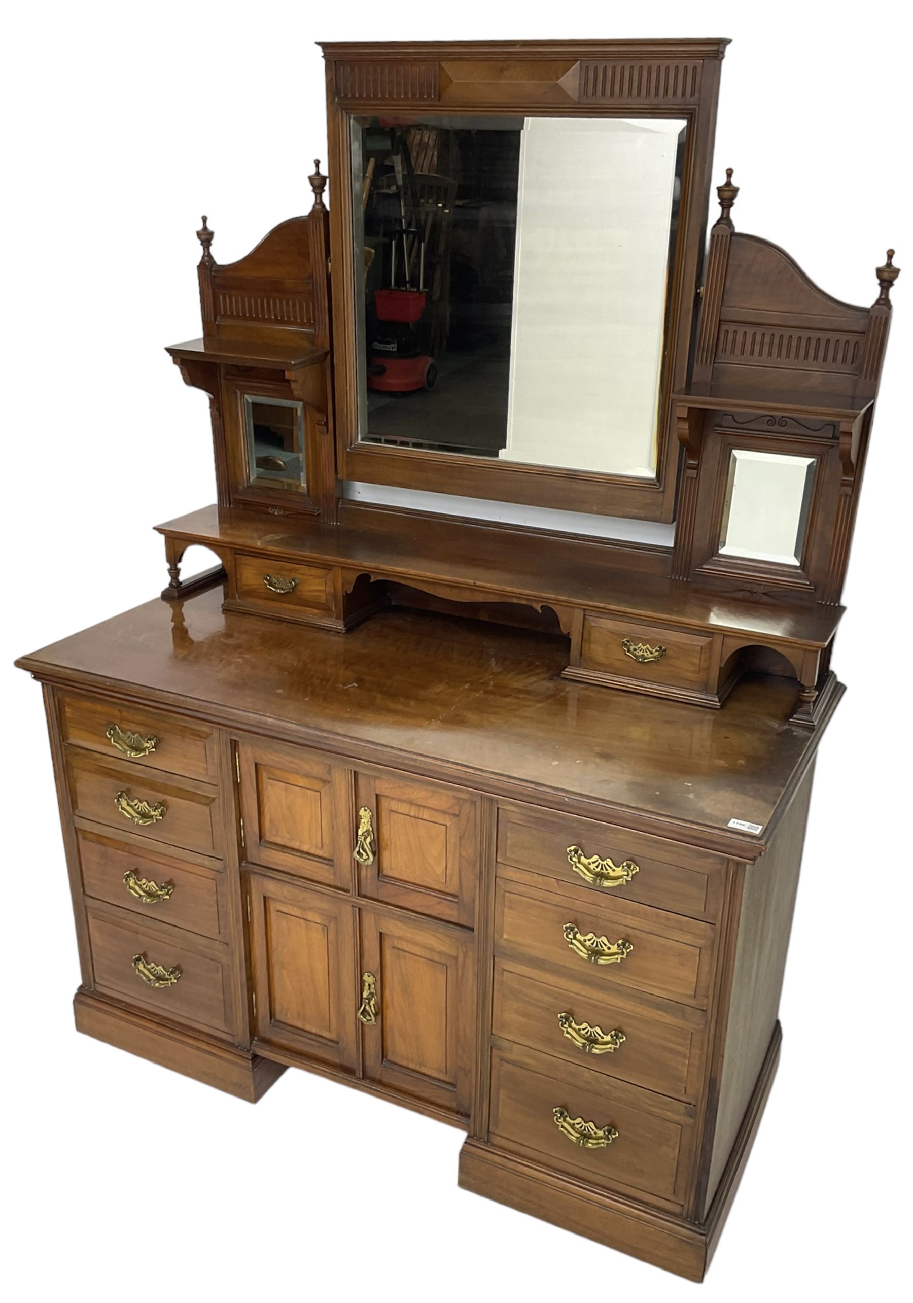 Edwardian mahogany dressing chest, raised triple mirror back with bevelled plates and fluted decoration over two trinket drawers, the base fitted with two central cupboards flanked by four graduating drawers to each side