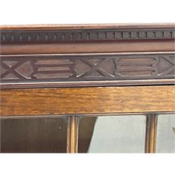 Early 20th century mahogany bookcase, projecting dentil cornice over blind fretwork frieze, enclosed by two astragal glazed doors, on shaped bracket feet 