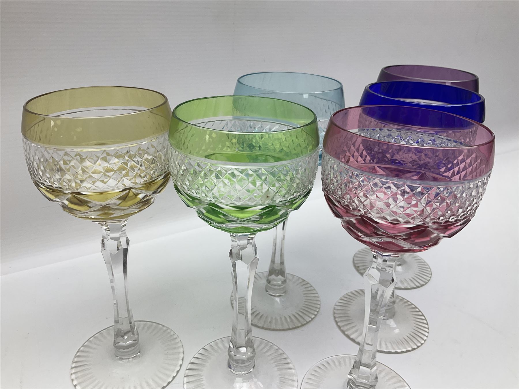 Set of six Harlequin coloured glass hock glasses, each with a band of hobnail decoration, upon faceted stems, H19.5cm