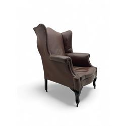 Early 20th century hardwood-framed wingback armchair, upholstered in brown fabric with stu...