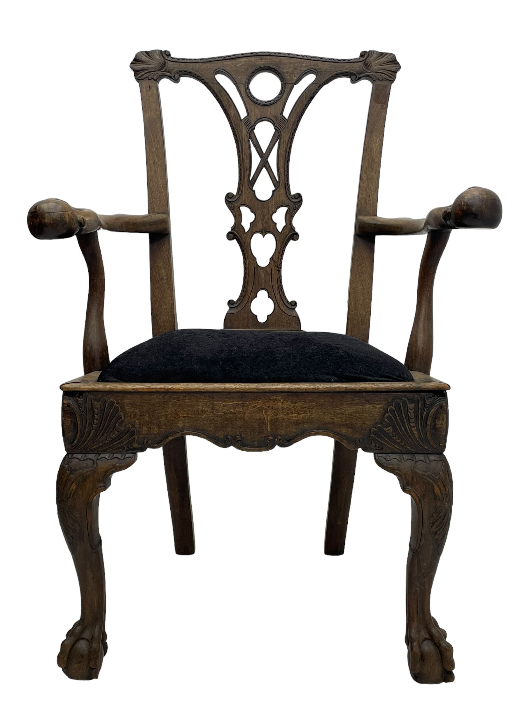 Unusual 18th century mahogany elbow chair, the shaped cresting rail with projecting shell carved ears, pierced and scroll carved splat over drop-in upholstered seat, shaped arms with ball and claw carved terminals, the seat rails carved with shell cartouches, on foliate carved cabriole supports with ball and claw feet 