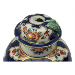 18th century Worcester tea caddy, of oval form and painted in the Kakiemon palette with reserves of flowers against a blue scale ground, H14cm together with a similar Worcester circular dish, painted with floral sprays, within a scalloped edge, blue crescent mark beneath, D19cm (2)