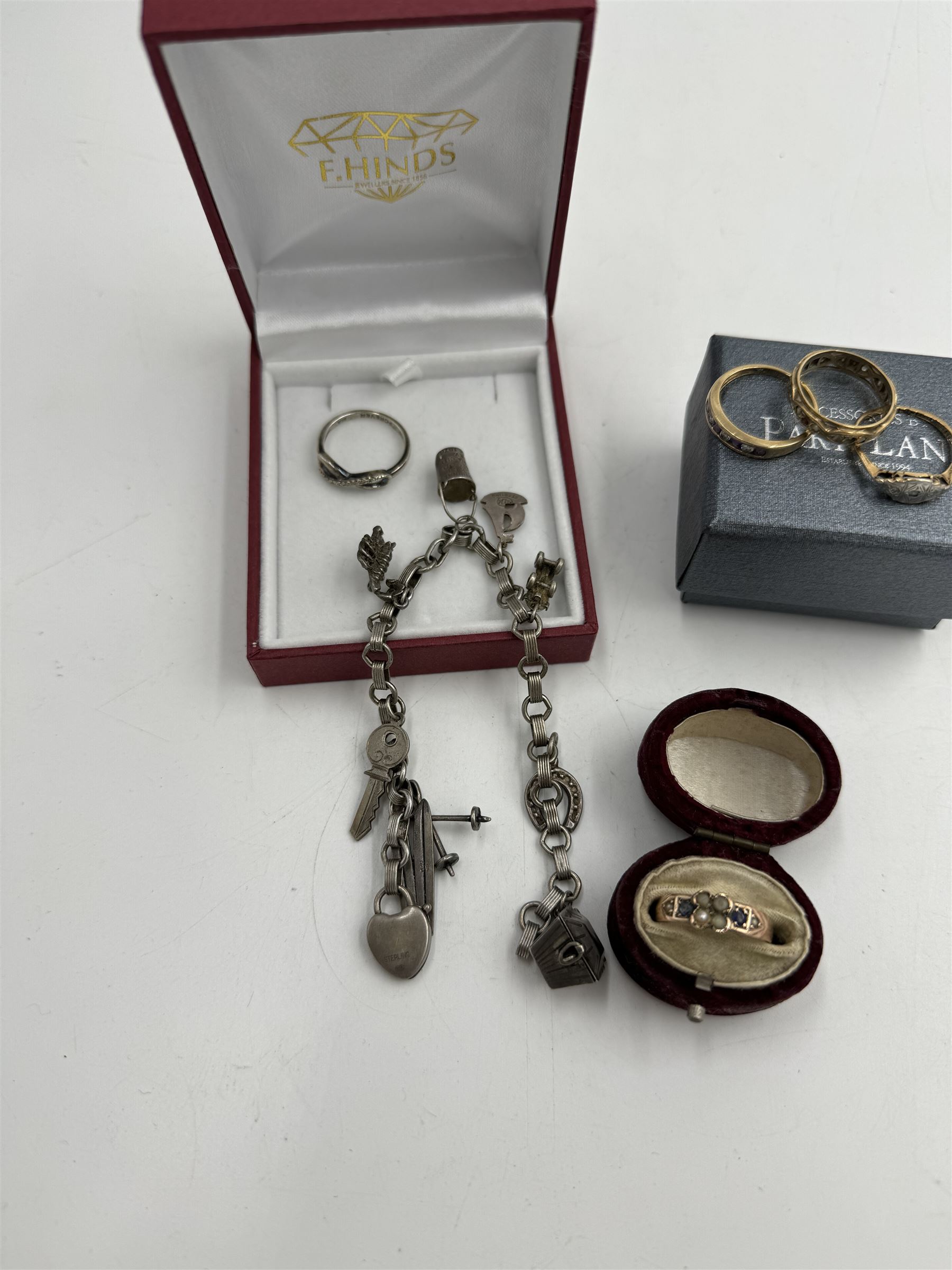 Four 9ct gold stone set rings, silver ring and a silver charm bracelet