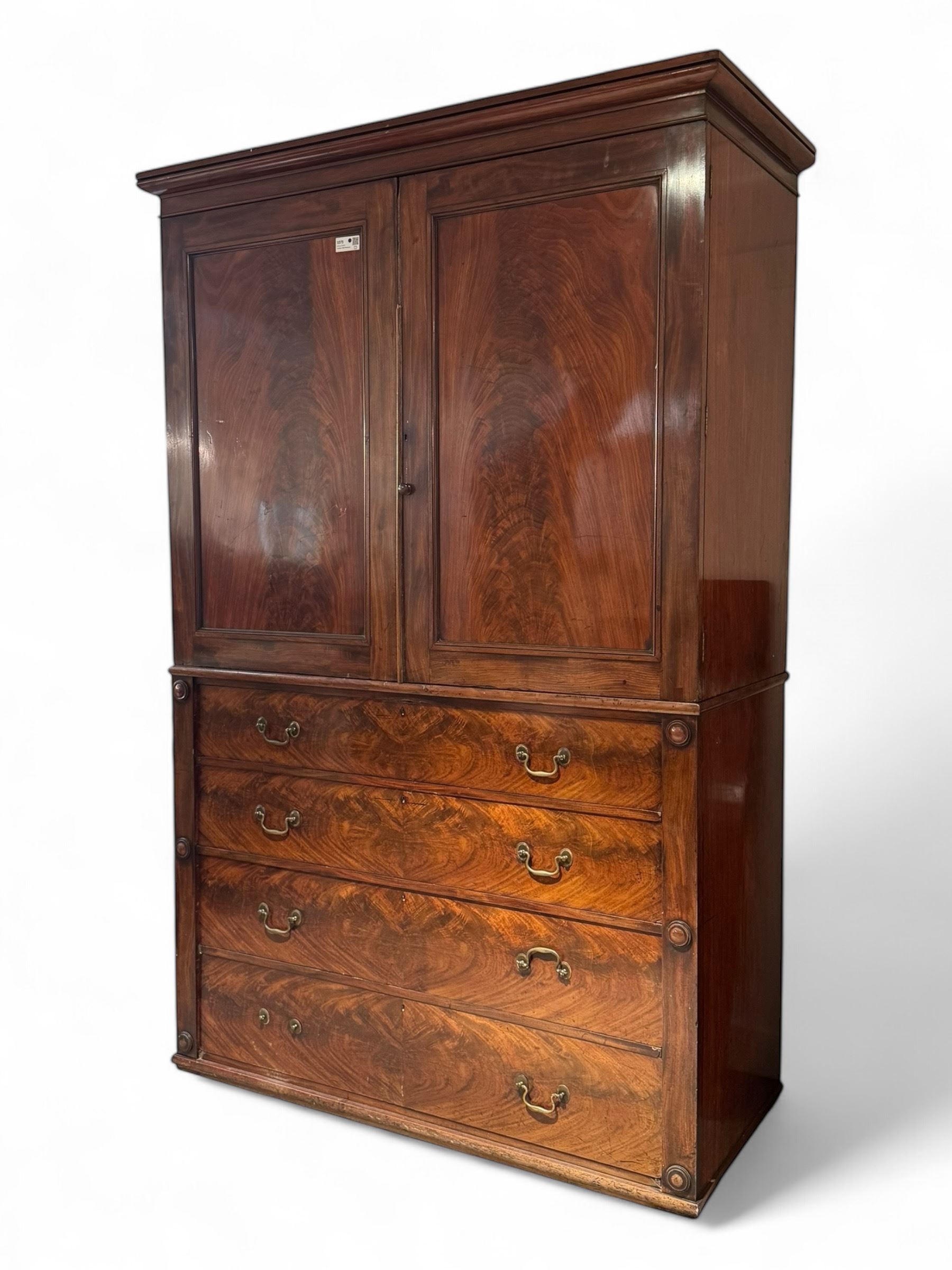 Victorian mahogany linen-press, moulded cornice over two figured panelled doors, the interior fitted with five slides and hanging rail, four long drawers below 