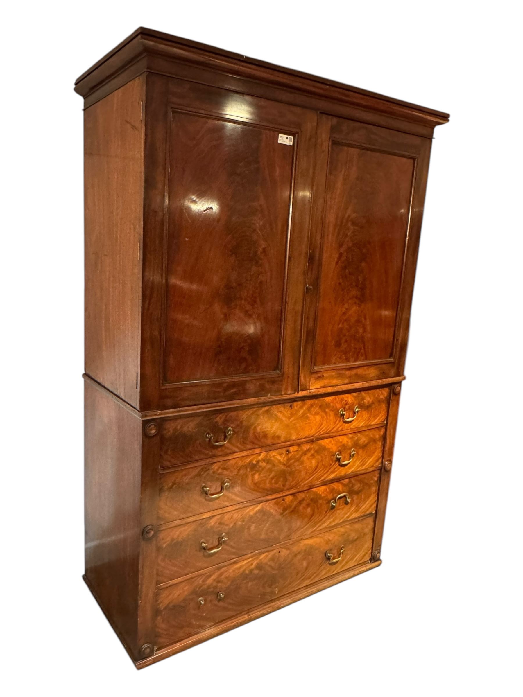 Victorian mahogany linen-press, moulded cornice over two figured panelled doors, the interior fitted with five slides and hanging rail, four long drawers below 