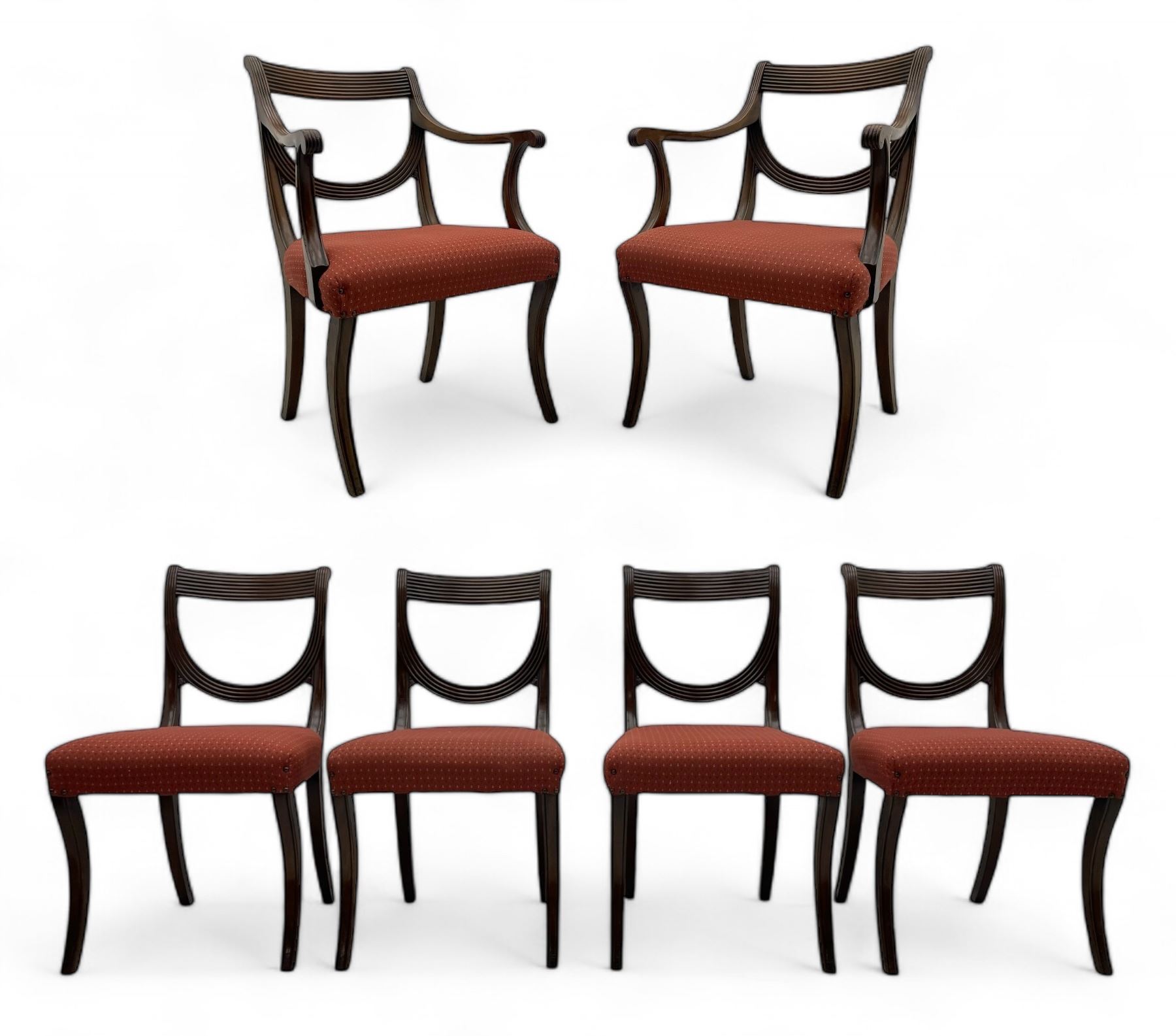 Set of six (4+2) George III design mahogany dining chairs, curved reed moulded bar back over curved and reeded middle rail, upholstered in red fabric with repeating pattern, on moulded sabre supports 