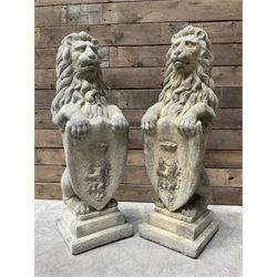 Pair large cast stone seated mighty Westcott lions, holding shield with coat of arms, rais...