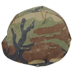 Collection of nine military helmets, including several with camouflage covering 