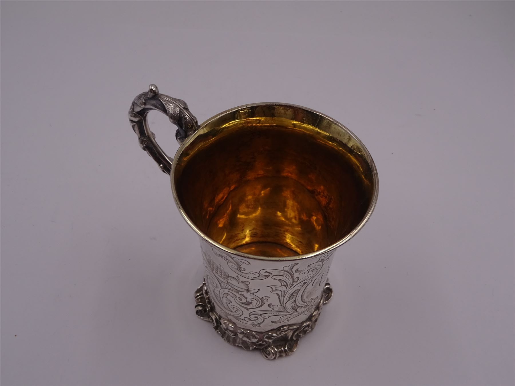 Victorian silver christening mug, of cylindrical form with fluted rim, gilt interior and acanthus capped C scroll handle, the body with later engraved decoration and initials, with embossed scroll base, hallmarked John Evans II, London 1840, including handle H10.2cm