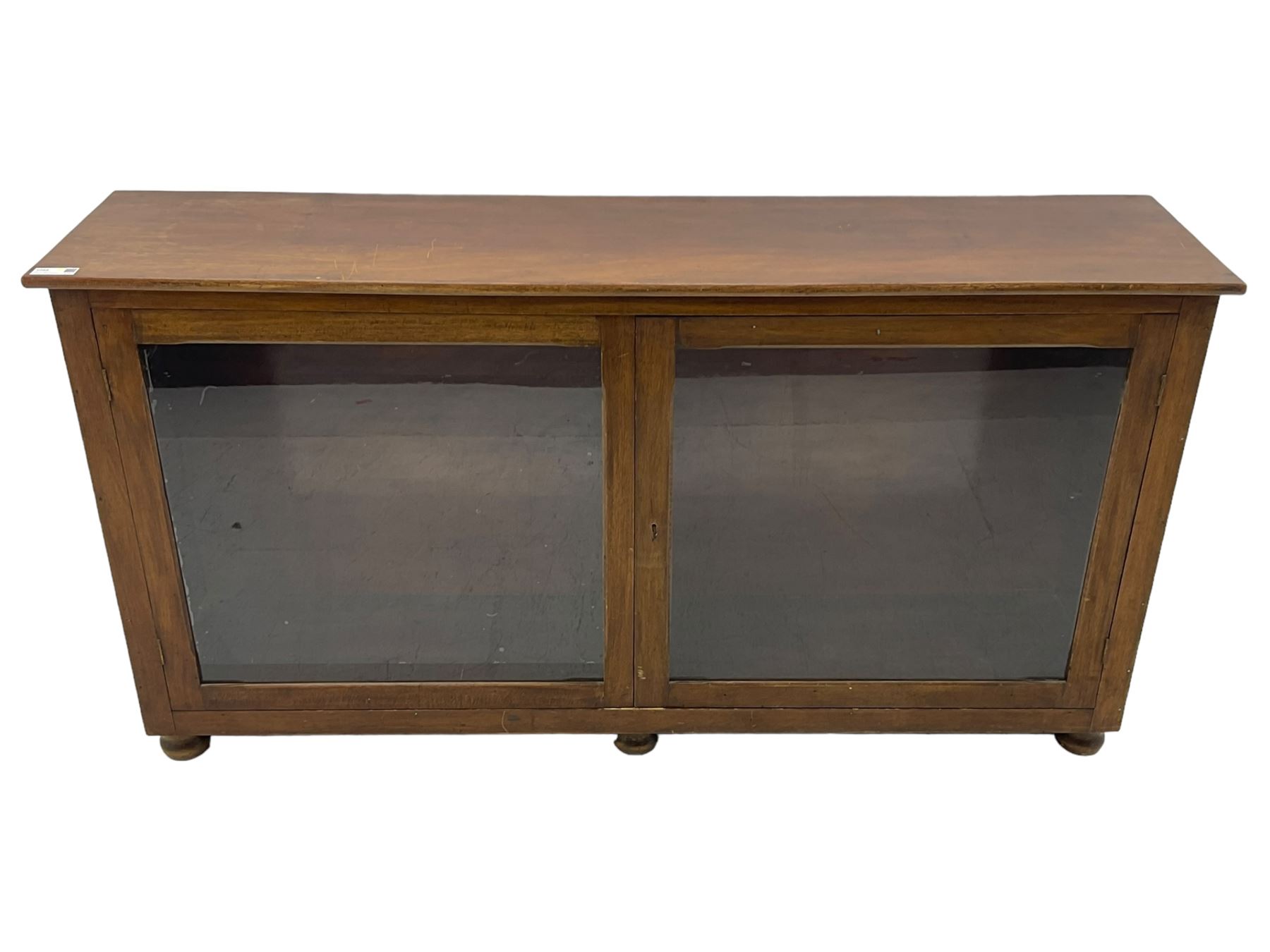 Early 20th century mahogany bookcase, rectangular top over two glazed doors, fitted with four adjustable shelves, on turned bun feet 