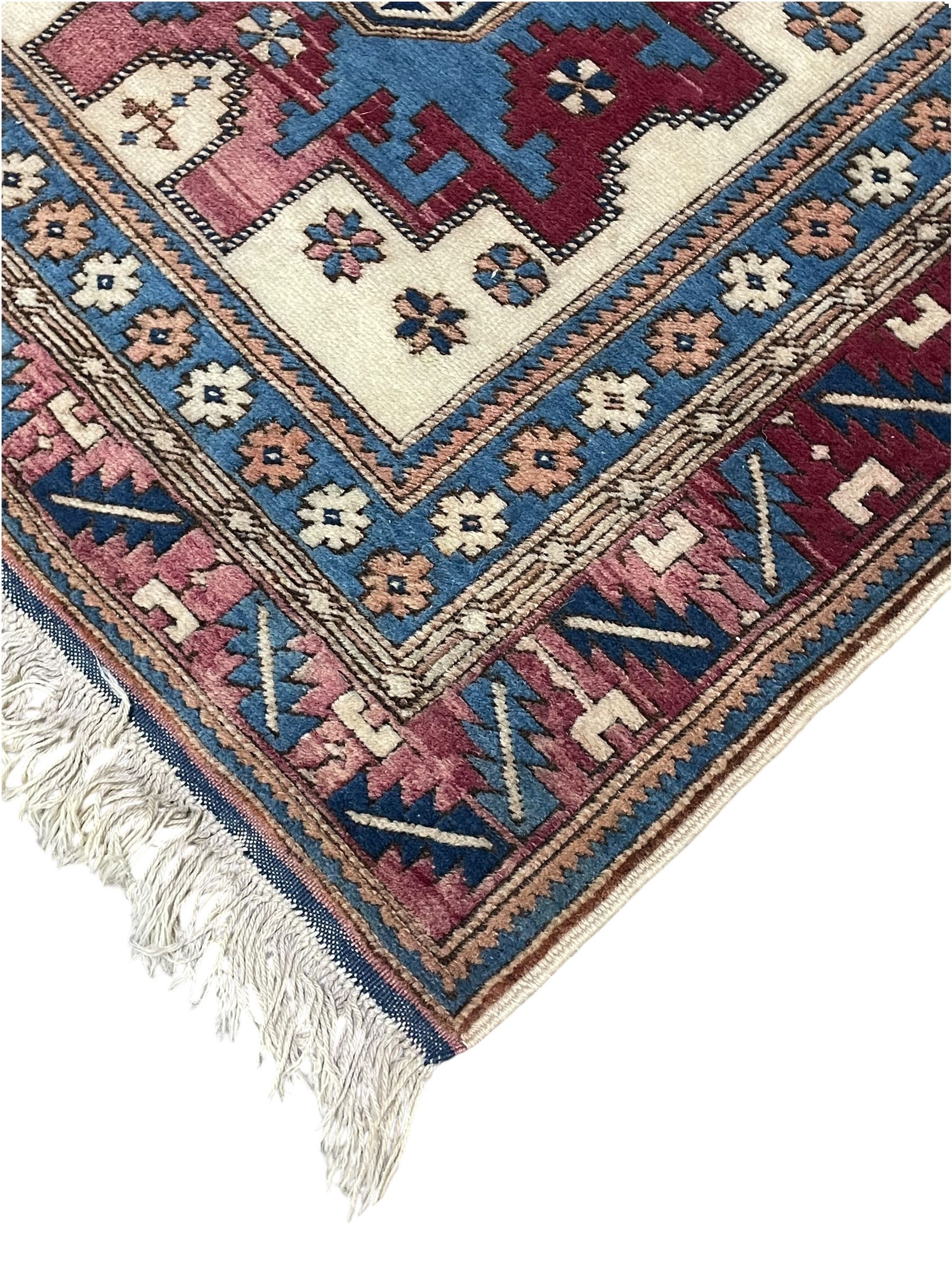 Turkish camel ground rug, three medallions surrounded by geometric motifs, the border decorated with stylised leaf motifs