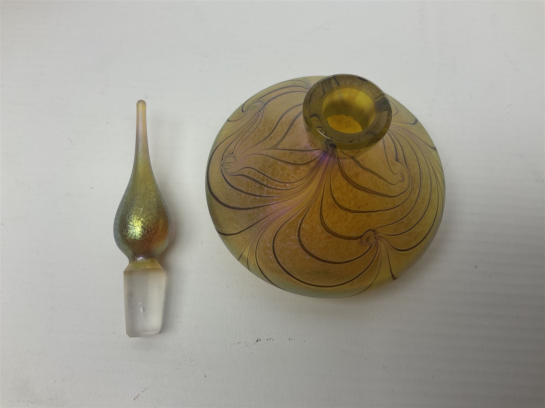 Four Okra scent bottles, the first example modelled as an apple, the second of squat form decorated with iridescent threads upon a gold ground and two others 