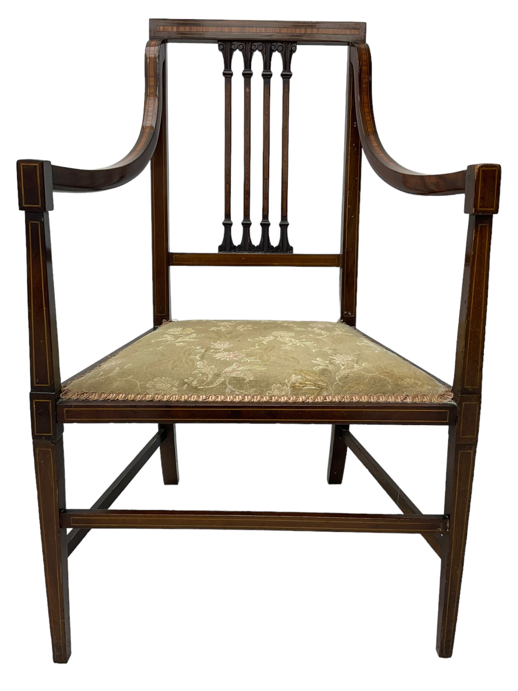 Edwardian satinwood inlaid mahogany elbow chair, the bar back over four vertical rails with foliate and scroll carved decoration, curved and down-swept arms, on square tapering supports united by stretchers 