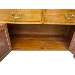 Early 20th century inlaid mahogany cabinet, two-door upper section revealing interior shelving and two large pull-out drawers, the lower section comprises two wide drawers flanked by inlaid floral motif panels above a double-door cupboard, supported by tapering legs with brass castors