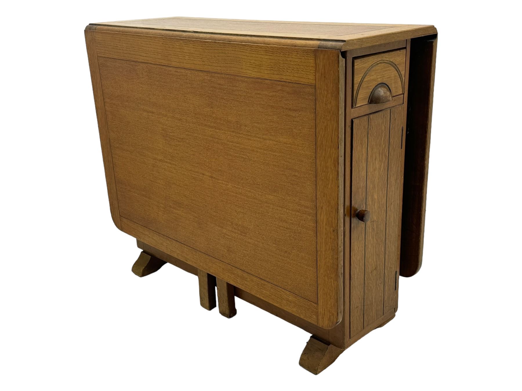 Early 20th century oak drop-leaf table, in the style of Harris Lebus, featuring rectangular top over central pedestal base, with two drawers and two cupboards, on gateleg supports