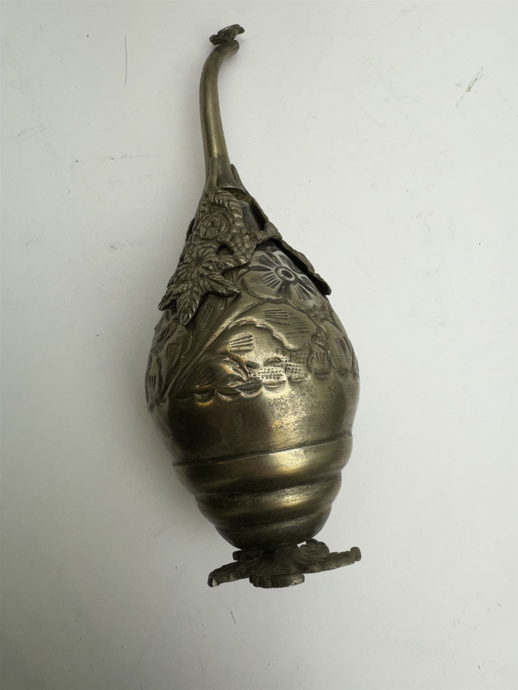 Egyptian white metal rosewater sprinkler, the pear shaped body embossed with flowers, the screw top with applied rose and bird decoration, upon foliate base, H20cm