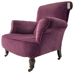 Late Victorian upholstered armchair, in deep purple velvet fabric, buttoned backrest, rolled arms, on splayed back and turned front supports with castors