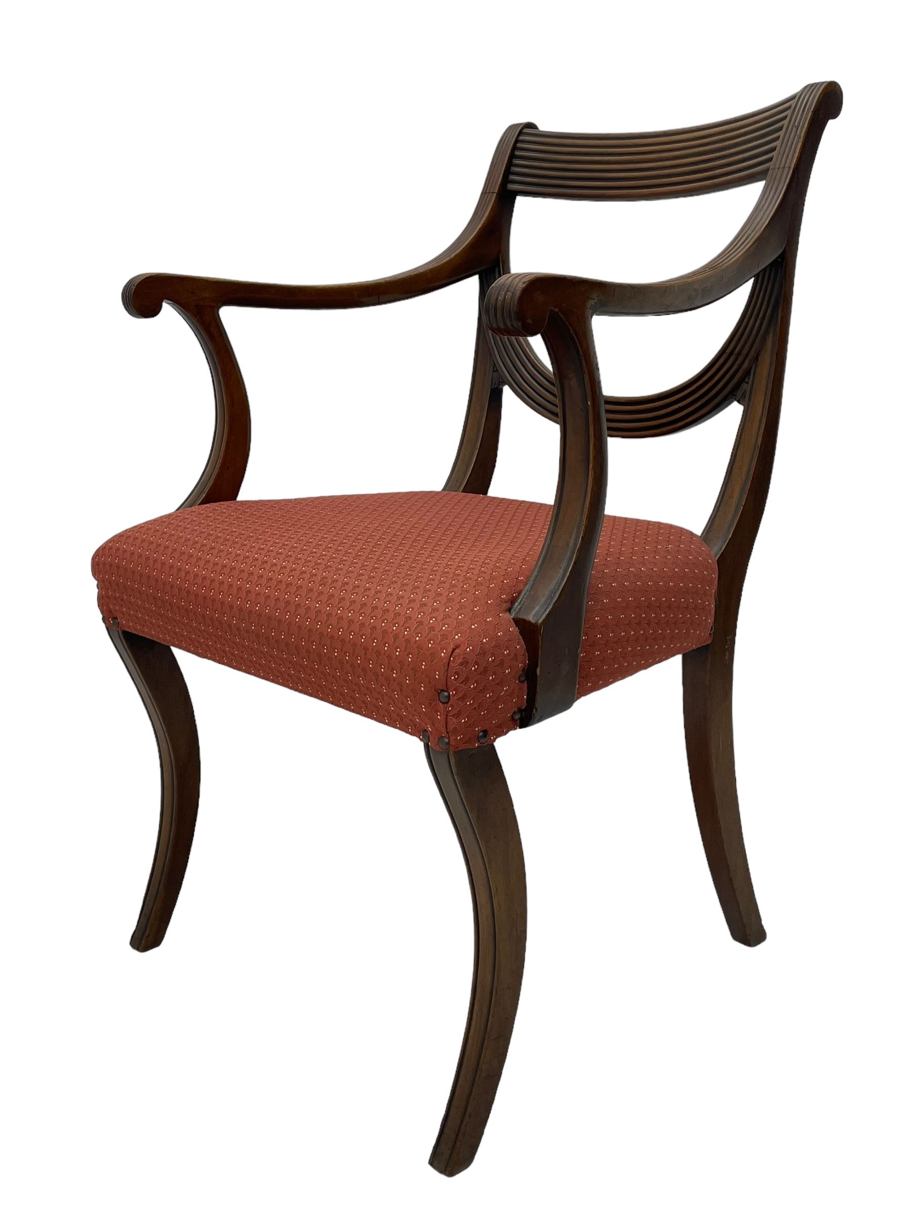 Set of six (4+2) George III design mahogany dining chairs, curved reed moulded bar back over curved and reeded middle rail, upholstered in red fabric with repeating pattern, on moulded sabre supports 