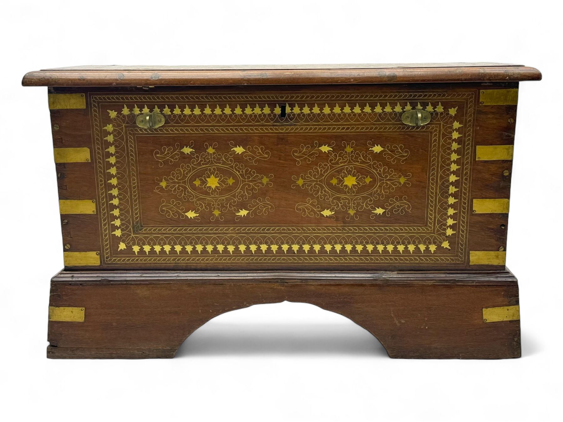 20th century mahogany chest, rectangular hinged top enclosing removable compartments with carved starburst motifs with linear and geometric patterns, brass inlay to the top and front, mounted corners and edges, on bracket base