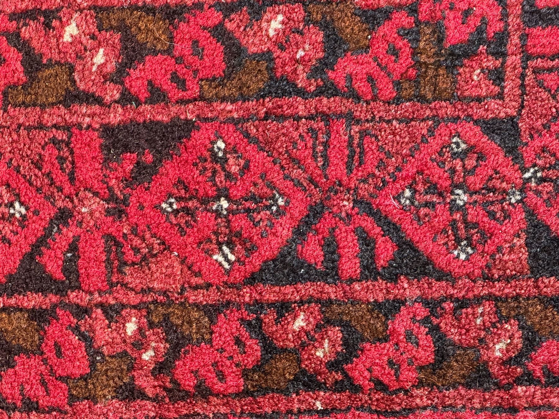 Afghan red ground Bokhara rug, decorated with four central Gul motifs, enclosed by wide geometric guard bands (191cm x 104cm); together with another similar (120cm x 79cm)