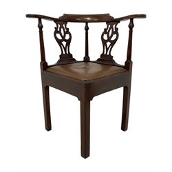 George III mahogany corner elbow chair, curved back rest and shaped arms with scroll carved terminals, on turned supports and pierced scroll carved interlaced splats, drop-in seat upholstered in brown leather, on square supports with inner chamfer and outer moulding 