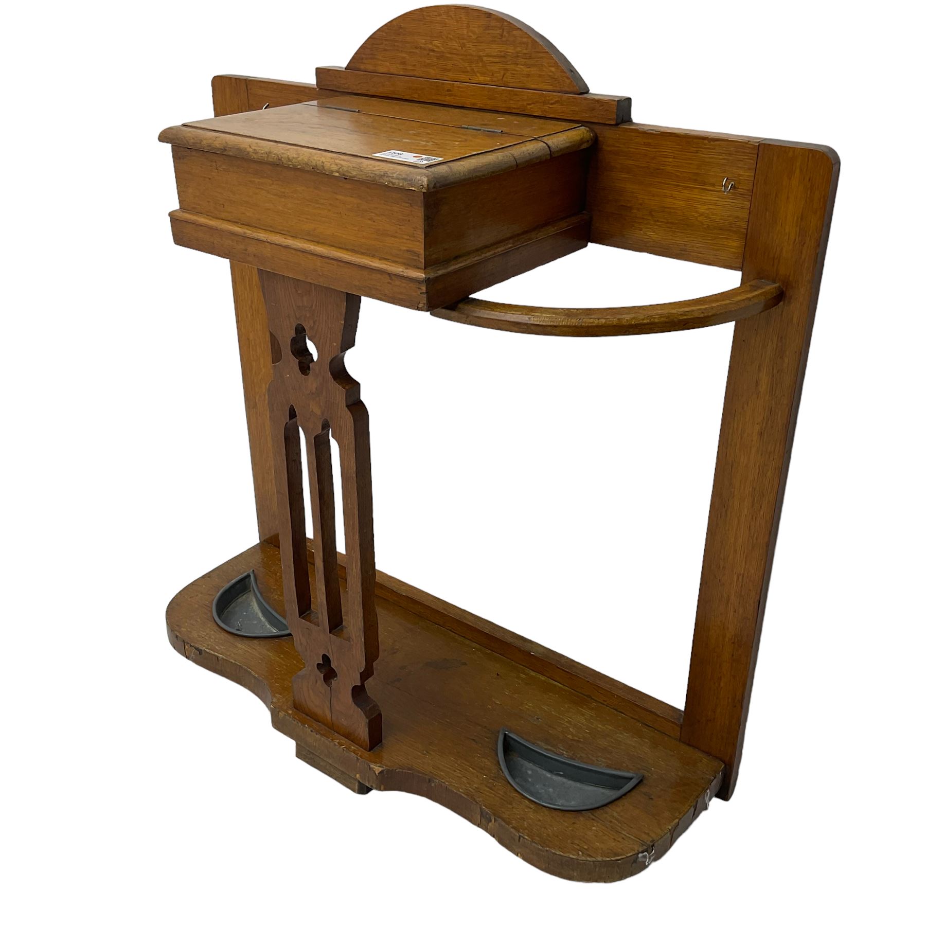 Arts & Crafts period golden oak hallstand, central glove compartment with moulded hinged top, over a Gothic pierced splat, flanking curved umbrella or stick stands