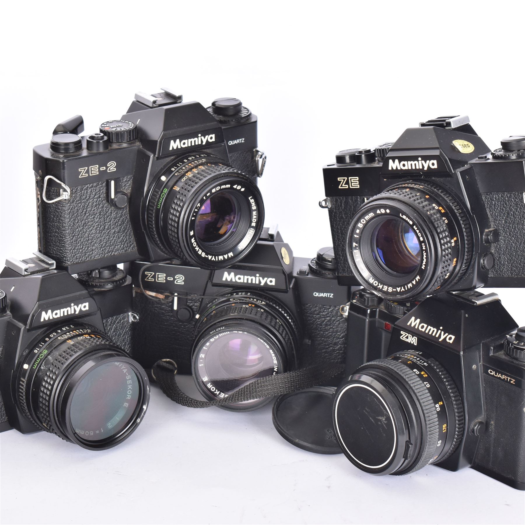 Five Mamiya SLR camera bodies, to include two ZE examples, serial nos. N171962 & N101512, one with a Mamiya-Sekor E 1:1.7 f-50mm lens serial no. 73984, the other with a Mamiya-Sekor E 1:2 f=50mm lens serial no. 48130, two ZE-2 camera bodies serial nos. N10753 & N328146, one with a Mamiya-Sekor E 1:1.7 f-50mm lens serial no. 93361 the other with a Mamiya-Sekor E 1:2 f=50mm lens serial no. 40170 and a ZM camera body serial no. V206108, with a Mamiya-Sekor E 50mm 1:1.7 S lens