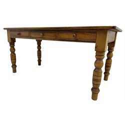 Waxed pine dining table, rectangular top with rounded corners over three drawers, on turned supports