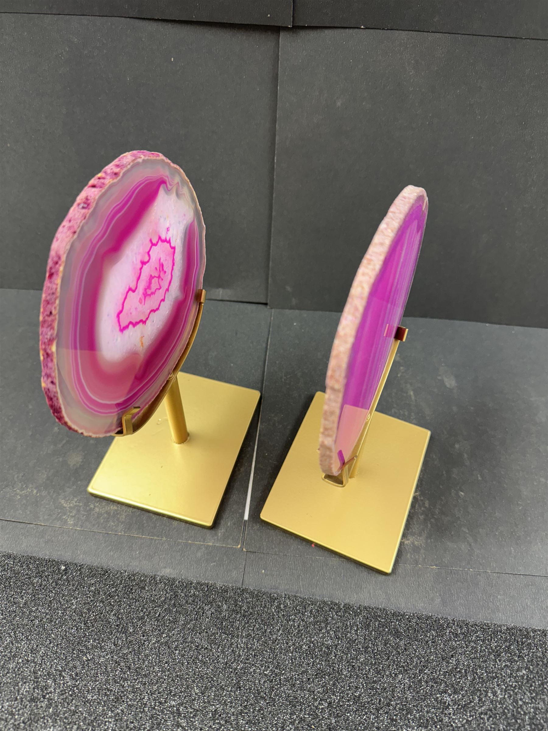 Pair of pink agate slices, polished with rough edges, raised upon gilt metal stands, H20cm