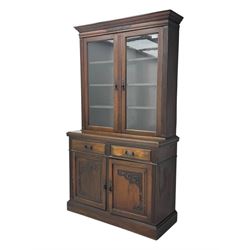 Edwardian walnut bookcase on cupboard, projecting moulded cornice over two glazed doors en...