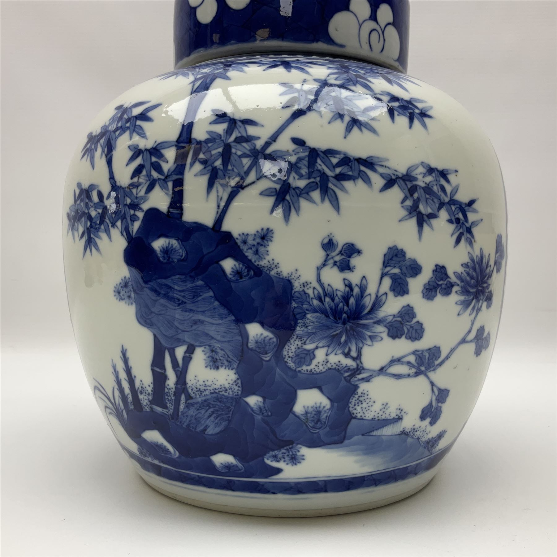 Chinese blue and white ginger jar, painted with bamboo and blossoming trees in panels against a flowerhead ground, H24cm